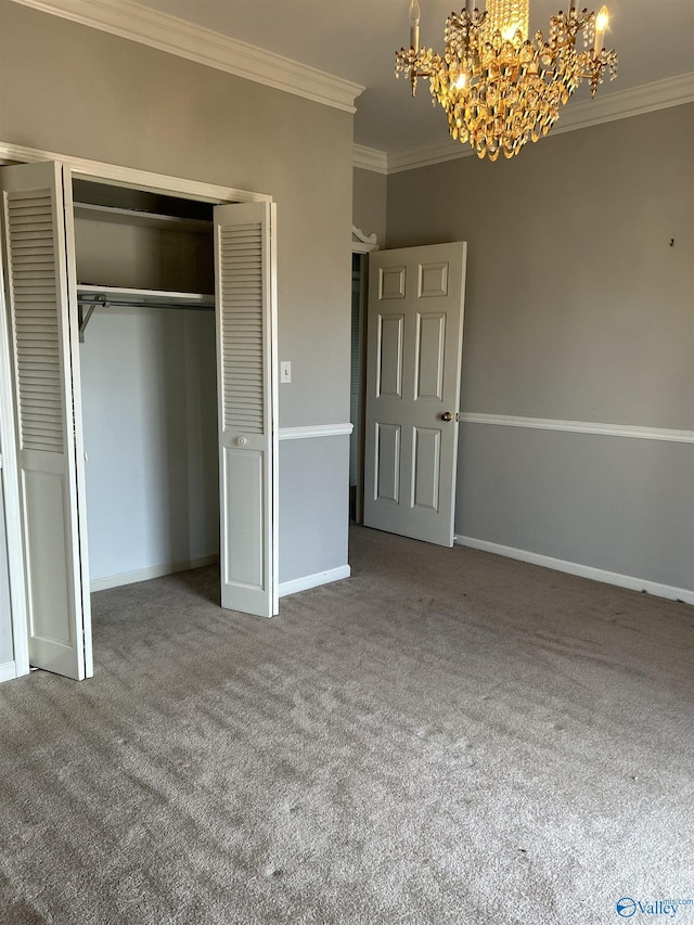 unfurnished bedroom featuring ornamental molding, carpet floors, a closet, and a notable chandelier