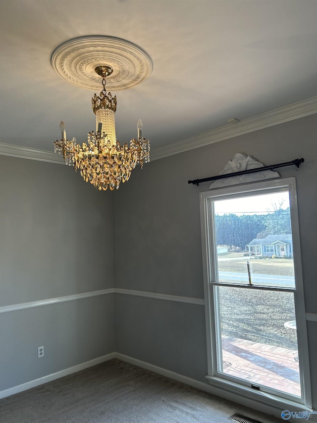 carpeted spare room with a notable chandelier and ornamental molding