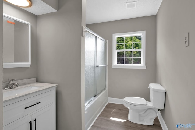 2221 Old Union Rd, Grant, AL 35747 - full bath featuring toilet, vanity, wood finished floors, baseboards, and enclosed tub / shower combo