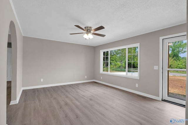 2221 Old Union Rd, Grant, AL 35747 - empty room with plenty of natural light, arched walkways, ceiling fan, a textured ceiling, and wood finished floors