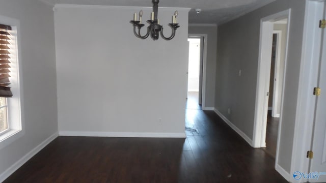 unfurnished dining area featuring crown molding, dark wood-type flooring, and a chandelier