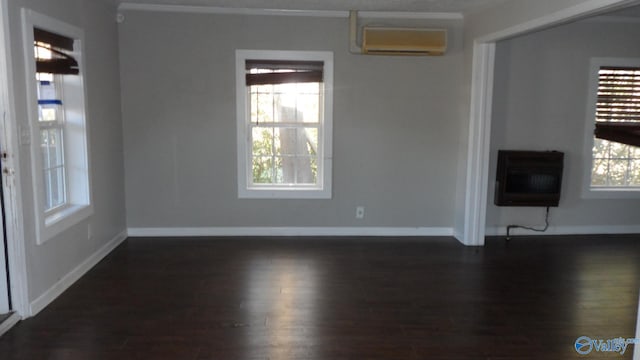 unfurnished living room featuring a wall unit AC, heating unit, plenty of natural light, and dark hardwood / wood-style floors