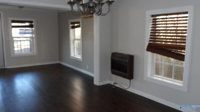 interior space with a notable chandelier, dark hardwood / wood-style flooring, and heating unit