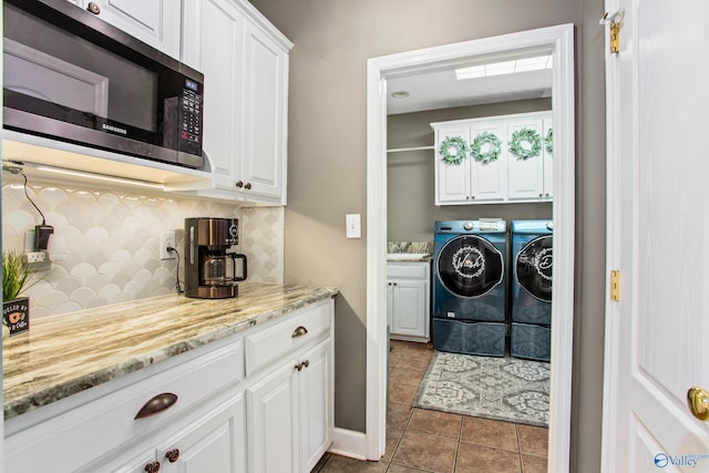 laundry area with separate washer and dryer, tile patterned floors, and cabinets