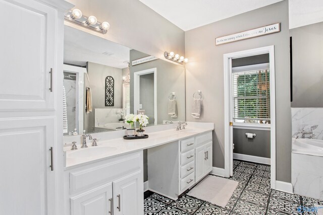 bathroom with a bathtub, double vanity, and tile patterned flooring