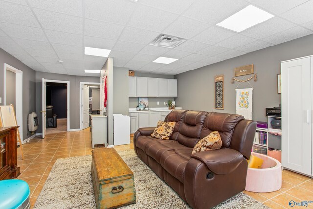 tiled office space featuring a drop ceiling and ceiling fan