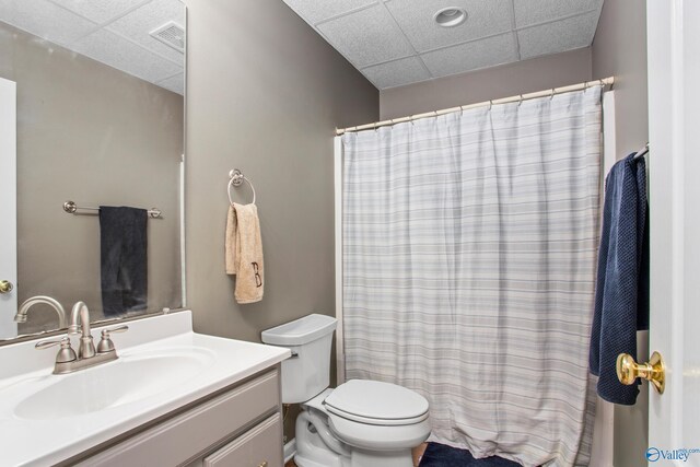 bathroom featuring a drop ceiling, toilet, and vanity