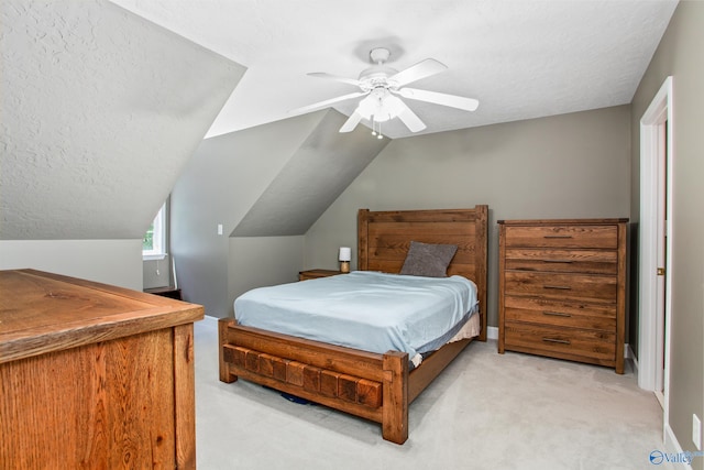 bedroom featuring a textured ceiling, ceiling fan, vaulted ceiling, and light carpet