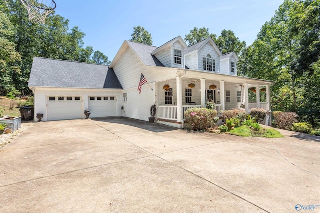 cape cod home featuring a garage and covered porch