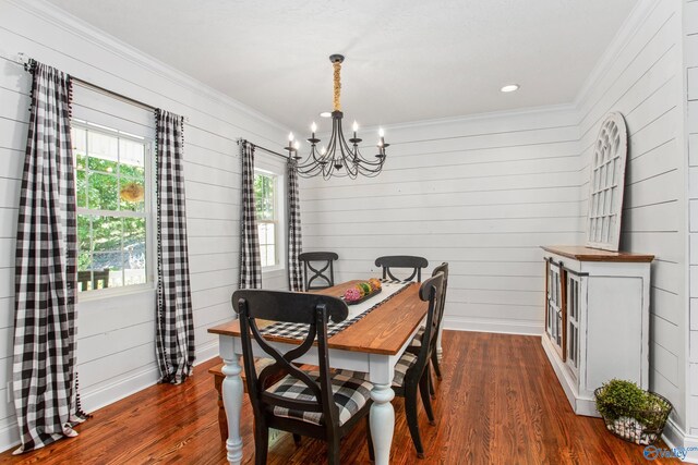 dining space with wood walls, a chandelier, ornamental molding, and hardwood / wood-style flooring