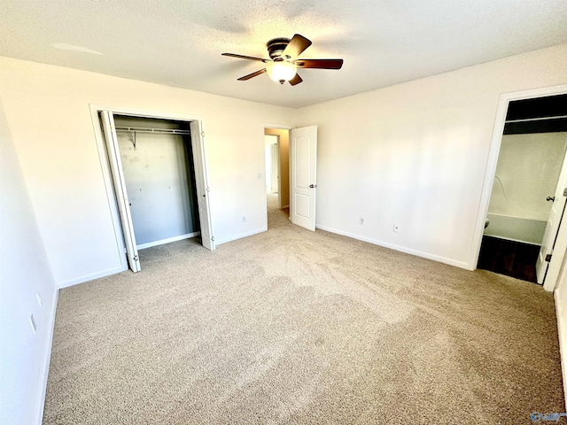 unfurnished bedroom with ceiling fan, light colored carpet, and a textured ceiling