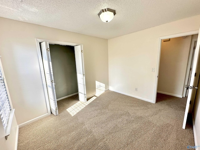 unfurnished bedroom with a closet, light colored carpet, and a textured ceiling