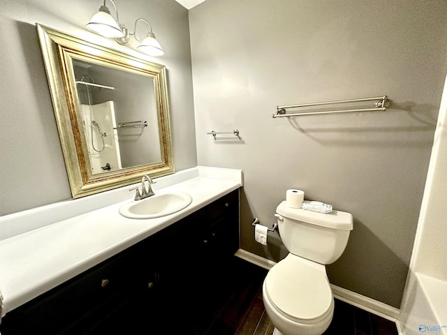 bathroom featuring hardwood / wood-style floors, vanity, toilet, and a shower