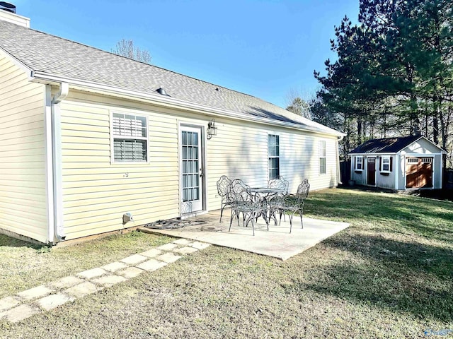 rear view of house featuring a lawn, a patio area, and a storage shed