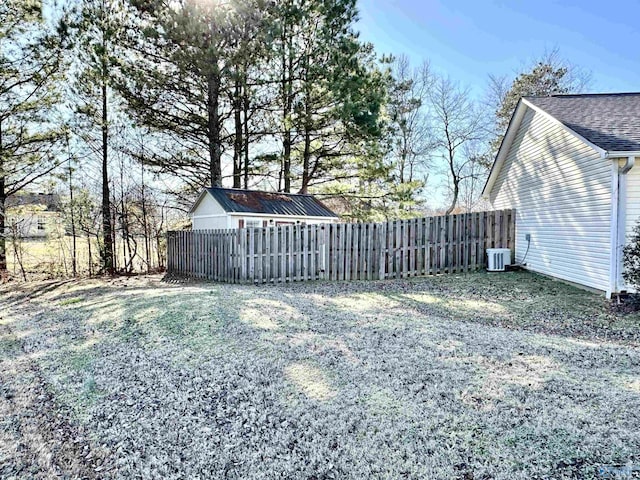 view of yard with central air condition unit and a storage shed