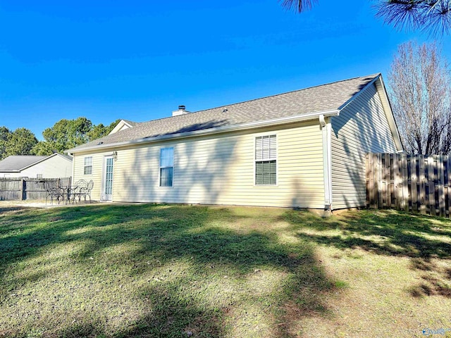 back of house with a lawn