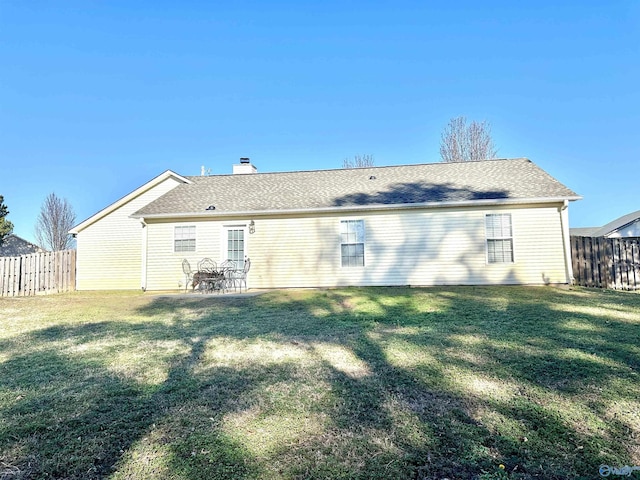 rear view of house featuring a yard and a patio