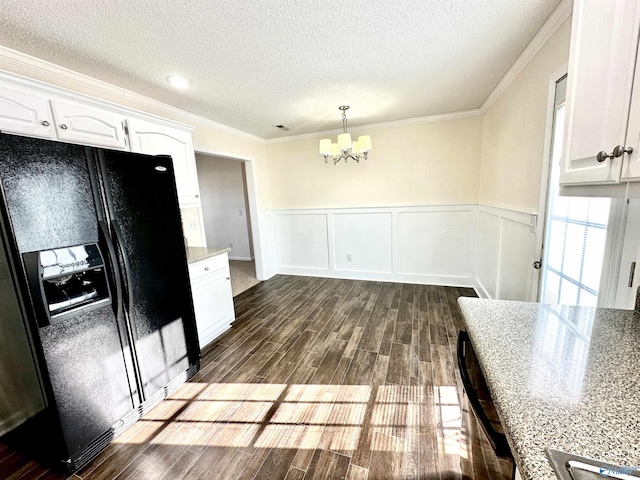 kitchen with black fridge with ice dispenser, crown molding, white cabinets, a chandelier, and hanging light fixtures