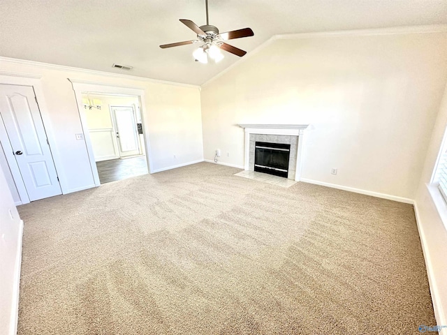 unfurnished living room featuring carpet flooring, vaulted ceiling, ceiling fan, crown molding, and a fireplace