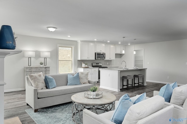 living room with dark wood-style floors, baseboards, and recessed lighting