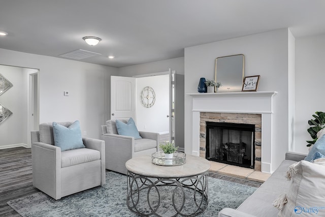 living room with a stone fireplace and hardwood / wood-style flooring