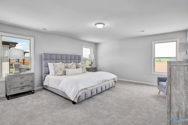 bedroom with light carpet, visible vents, and baseboards