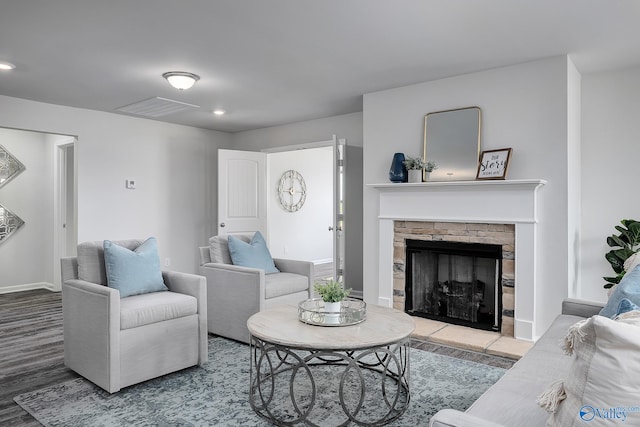 living room featuring baseboards, visible vents, wood finished floors, a fireplace, and recessed lighting