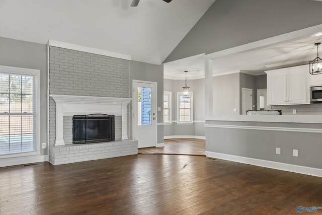 living room featuring a fireplace, vaulted ceiling, built in features, and hardwood / wood-style flooring