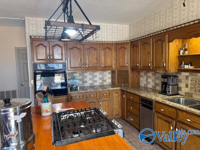 kitchen with wallpapered walls, brown cabinets, and black oven