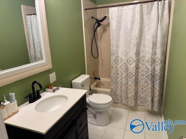 full bathroom featuring vanity, tile patterned floors, toilet, and shower / tub combo with curtain