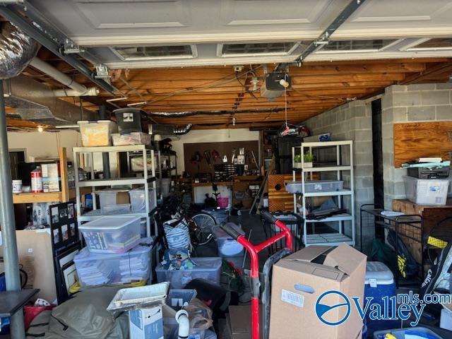 garage featuring a garage door opener and concrete block wall