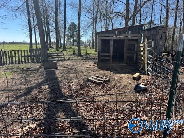 view of yard with fence and an outbuilding