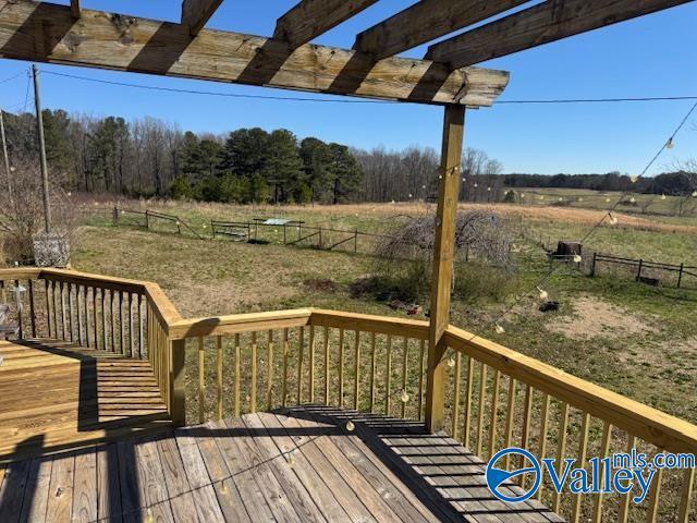 wooden deck featuring a rural view and fence