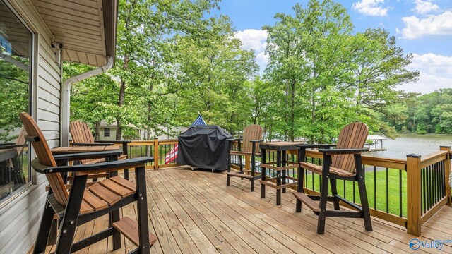 wooden deck featuring a water view and grilling area