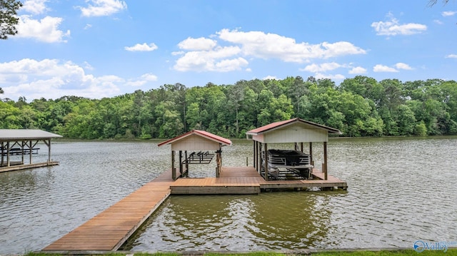 dock area with a water view, boat lift, and a forest view