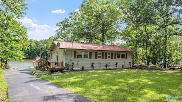 single story home featuring a front lawn and metal roof