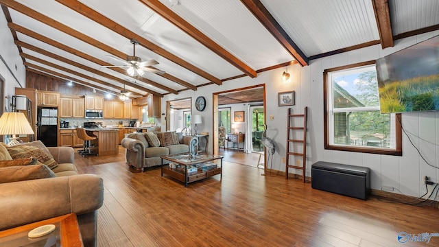 living room with ceiling fan, vaulted ceiling with beams, and wood finished floors