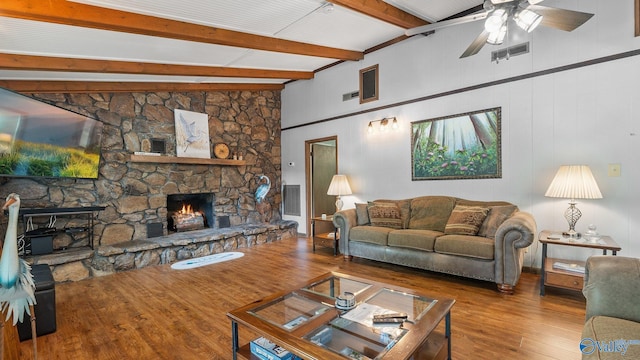 living room with wood finished floors, visible vents, a fireplace, ceiling fan, and beamed ceiling