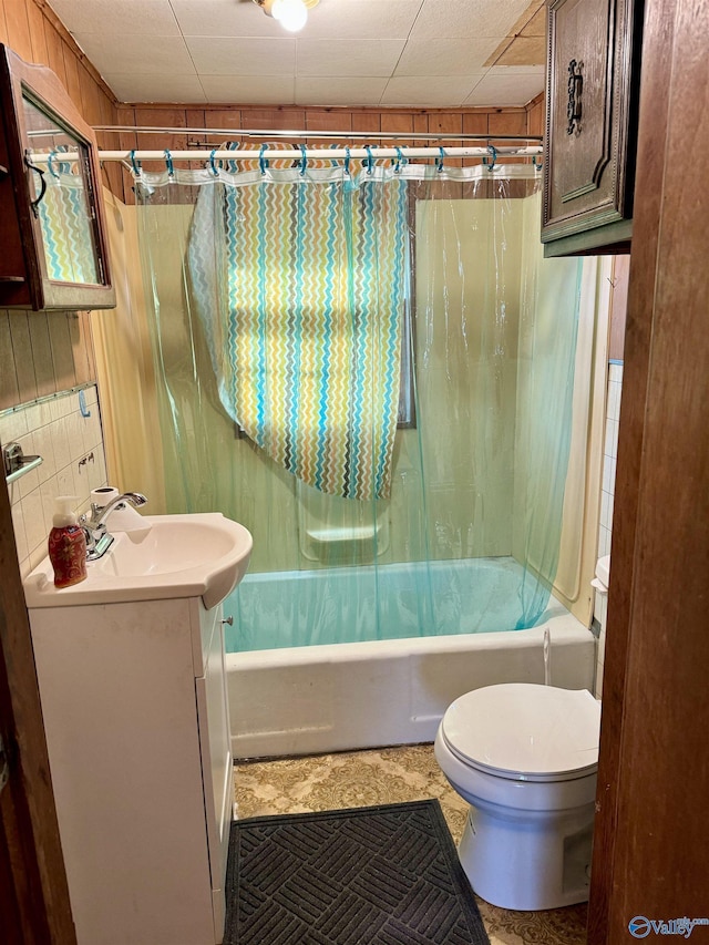 bathroom featuring toilet, shower / bath combo, decorative backsplash, and vanity