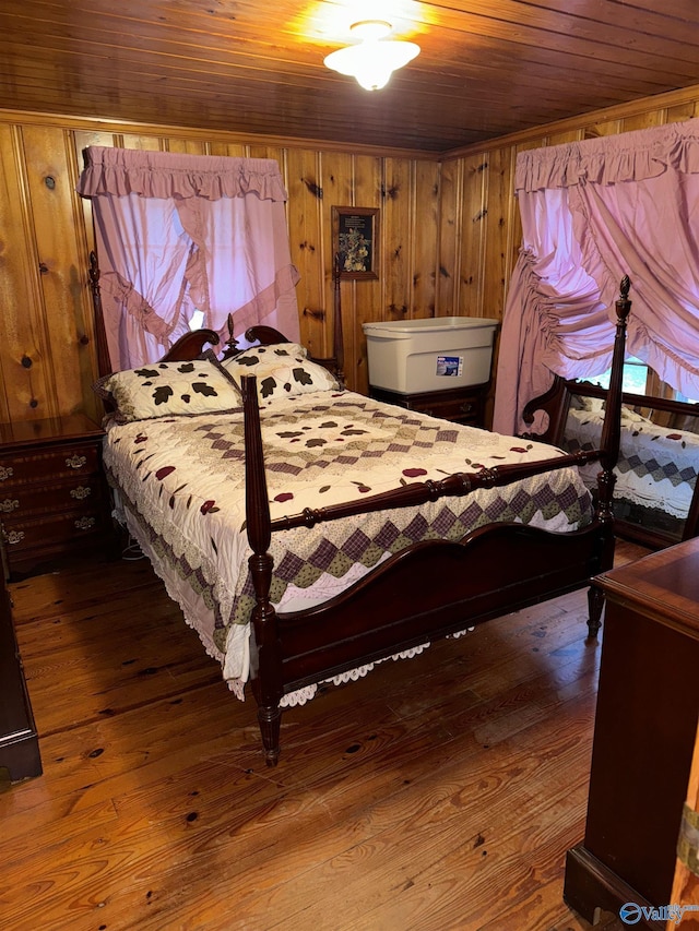 bedroom with wooden ceiling, wood finished floors, and wooden walls