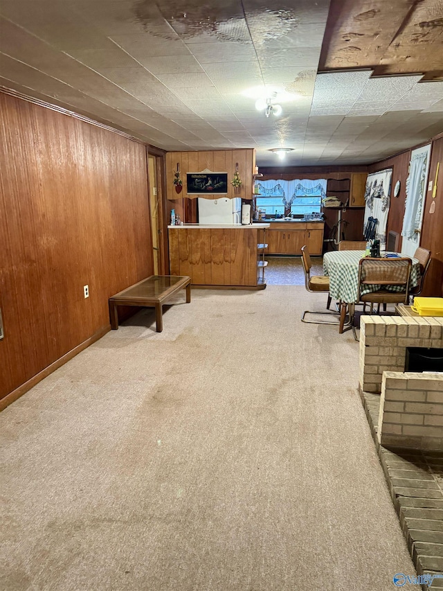 living area featuring wood walls and light colored carpet