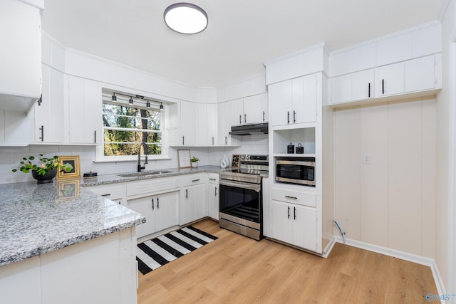 kitchen with sink, backsplash, stainless steel appliances, light stone counters, and white cabinets