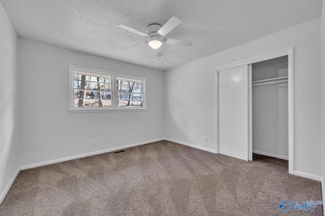 unfurnished bedroom featuring a closet, a textured ceiling, and carpet