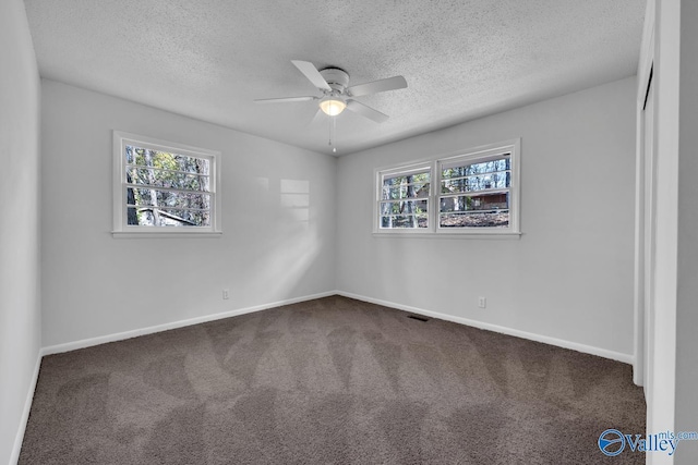 unfurnished bedroom featuring ceiling fan, carpet floors, and a textured ceiling