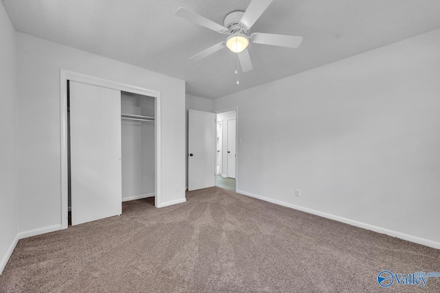 unfurnished bedroom featuring carpet, a textured ceiling, ceiling fan, and a closet