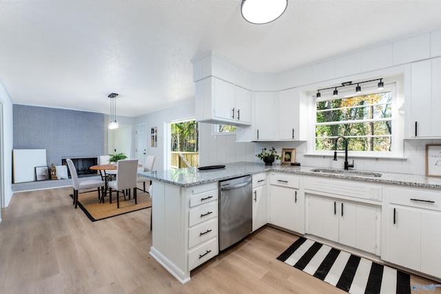 kitchen with pendant lighting, dishwasher, sink, white cabinets, and kitchen peninsula