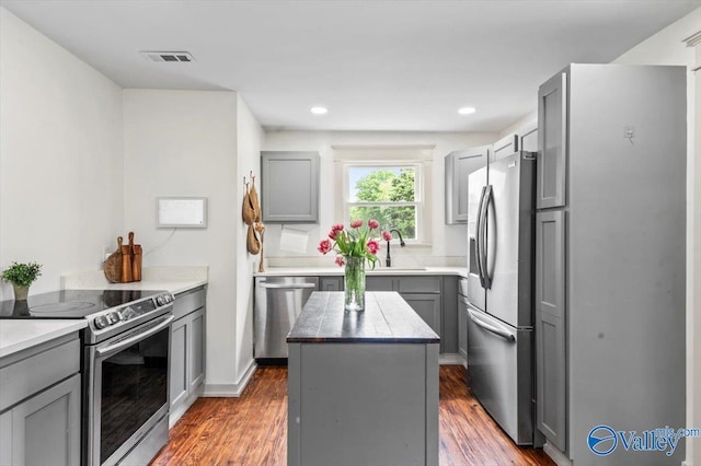 1760 Horseshoe Bend Rd, Scottsboro, AL 35769 - kitchen featuring appliances with stainless steel finishes, gray cabinets, a kitchen island, wood finished floors, and recessed lighting