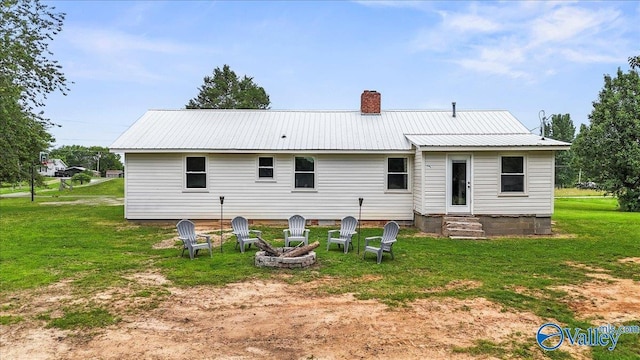1760 Horseshoe Bend Rd, Scottsboro, AL 35769 - back of property featuring a lawn, a chimney, an outdoor fire pit, and a metal roof
