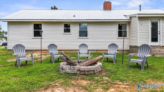 1760 Horseshoe Bend Rd, Scottsboro, AL 35769 - rear view of house featuring an outdoor fire pit, a lawn, and a metal roof