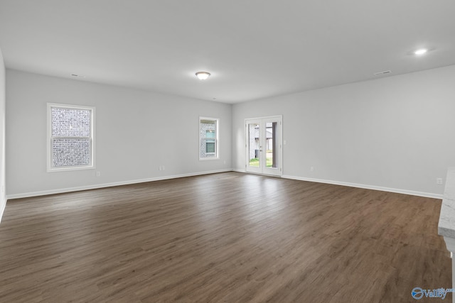 unfurnished room featuring dark wood-style flooring and baseboards